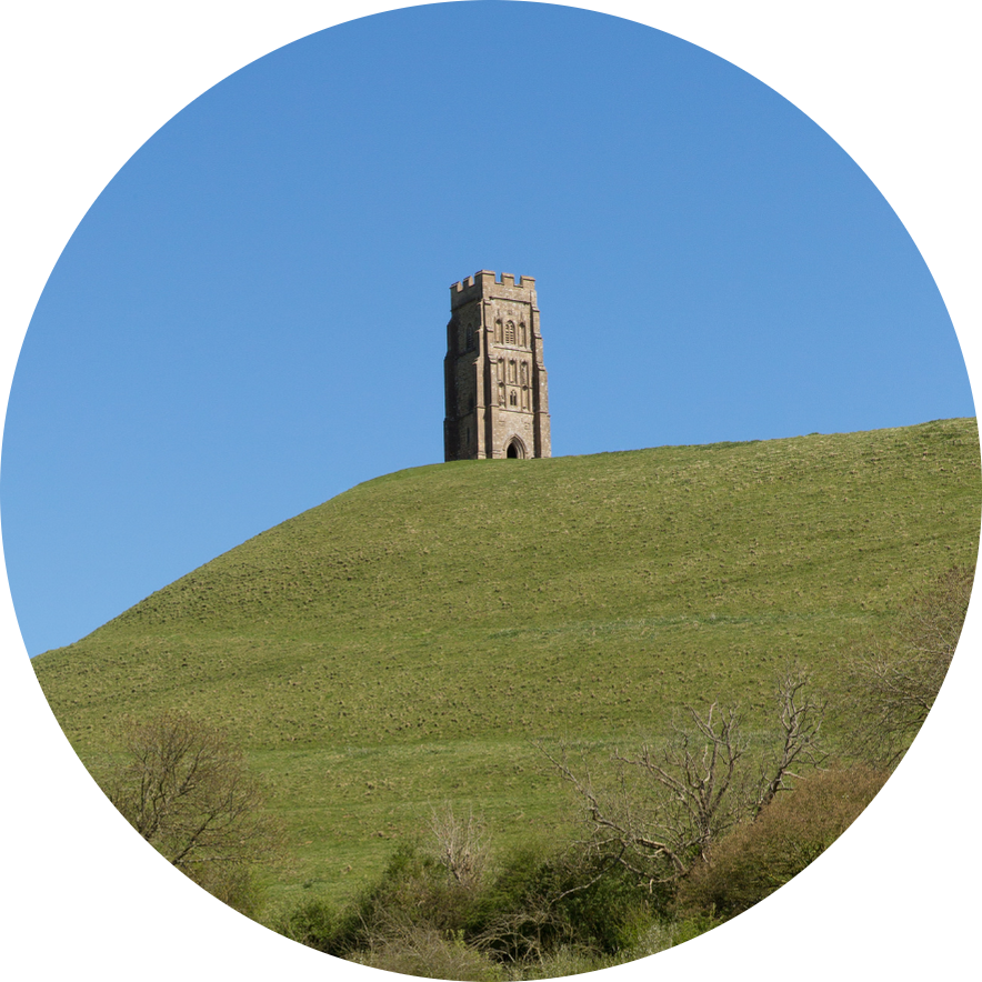 Glastonbury Tor tower on a hillside beneath a clear blue sky