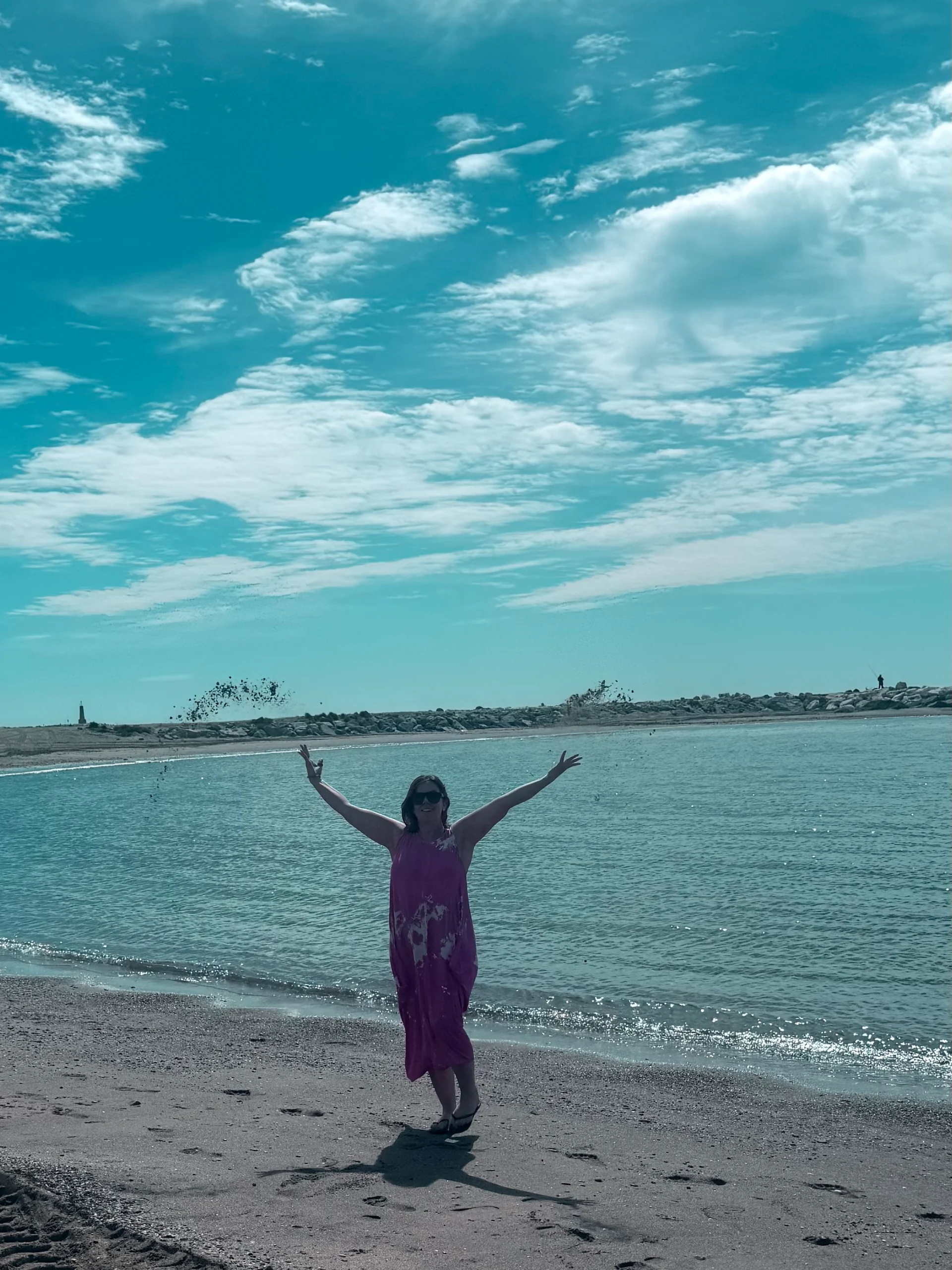 Alisha standing by the sea during a peaceful mindfulness and holistic healing moment